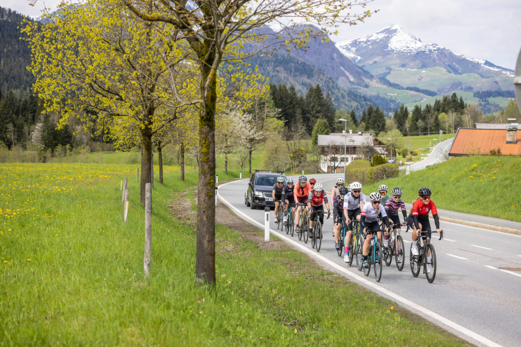 Radfahrende Frauen auf einer Straße im Oberpinzgau, umgeben von Natur und Bergen.